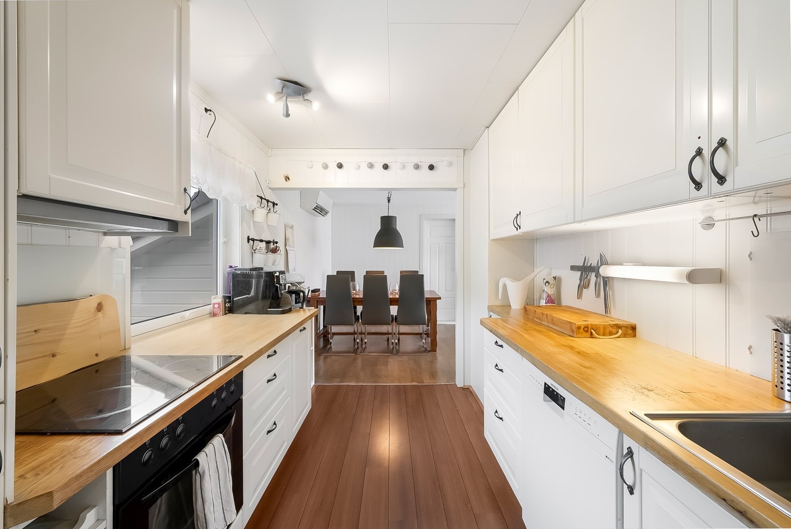 Åpen løsning fra kjøkkenet ut mot del av stua som er innredet med spisestue. Galleribilde