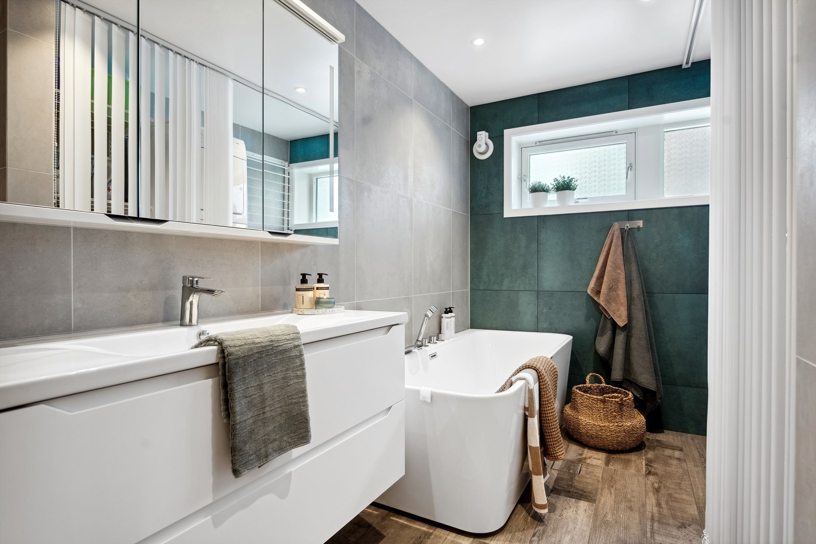 Vaskemaskin, tørketrommel, tørkestativ og varmtvannsbereder bak lameller sørger for et ryddig baderom. Galleribilde