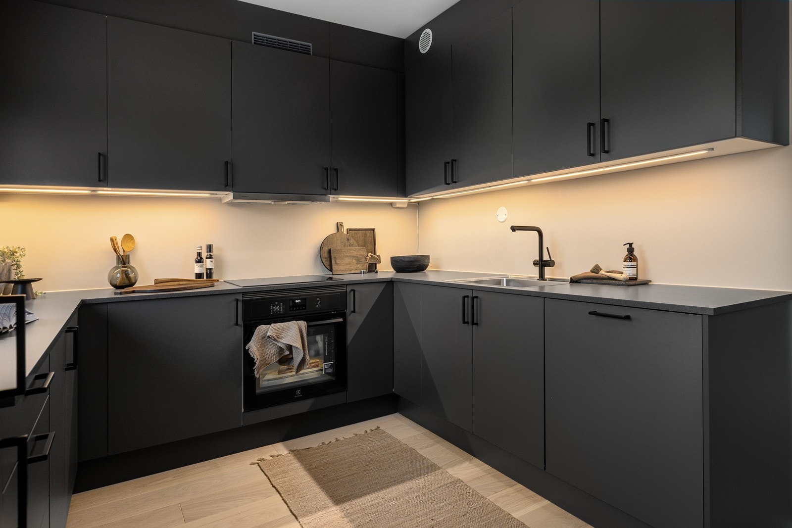 Innredningen består av slette fronter, laminat benkeplate med nedfelt kum og benkebelysning. Galleribilde