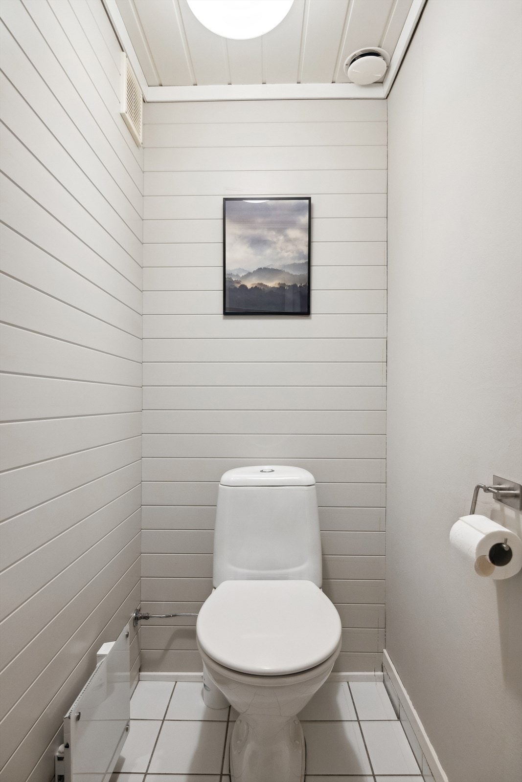 Toalettrommet har flislagt gulv, vegger med malte mdf plater og himling med malte mdf paneler som er fornyet i senere år, det er montert toalett og panelovn. Galleribilde