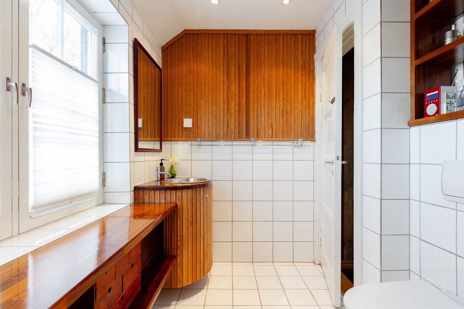 Det foreligger dokumentasjon for utførelsen på badet. Innredningen består av vegghengt wc, dusjhjørne og servant i snekkerbygget innredning. Galleribilde