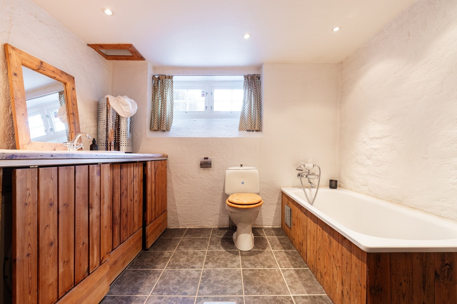 Badet består av wc, dusj i innebygget badekar og servant i snekkerbygget innredning. I tillegg er det opplegg for vaskemaskin og tørketrommel i skjult/innebygget plass. Galleribilde