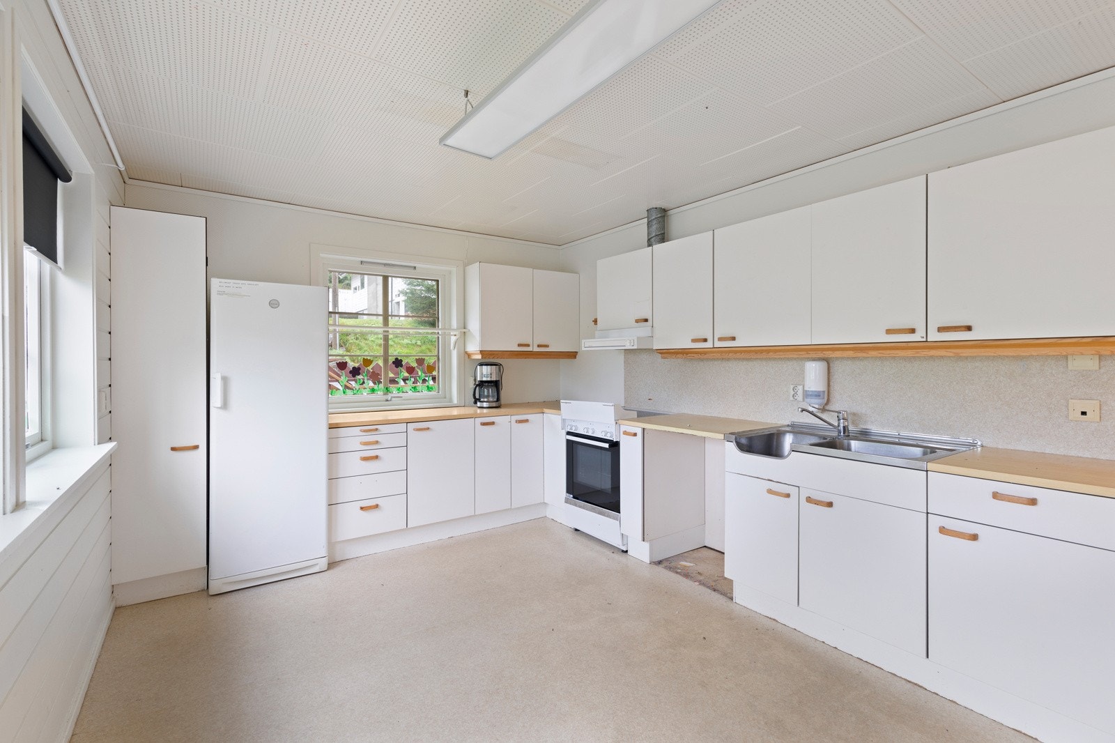 Kjøkken med hvite, slette fronter. Galleribilde