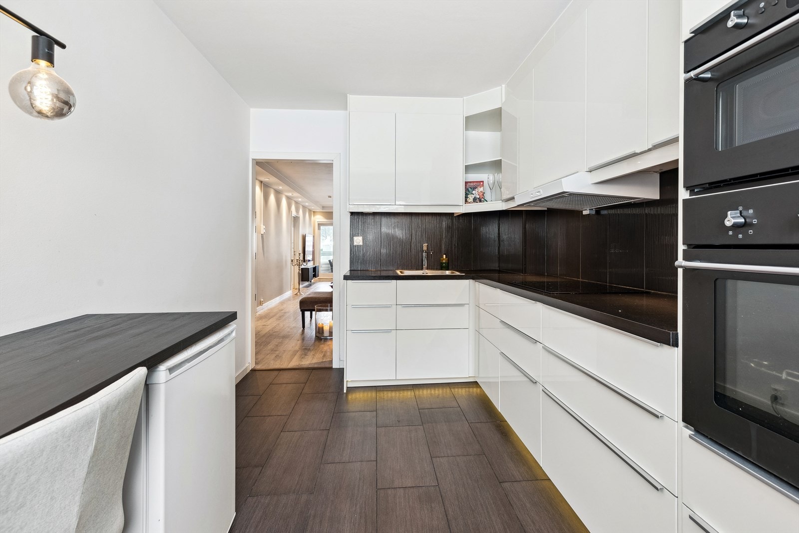 Mørke fliser pryder og beskytter bakveggen og gulvet på kjøkkenet Galleribilde