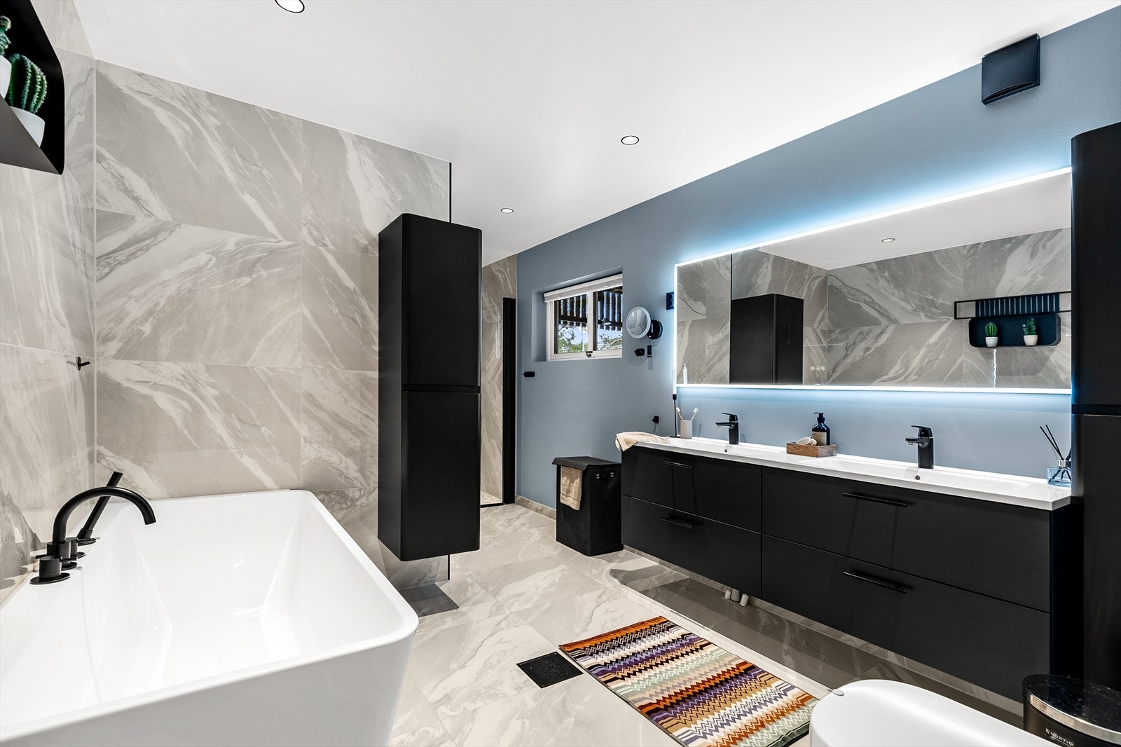 Hovedleilighet/Leilighet 1: Delikat og innholdsrikt baderom overflateoppusset i 2022 (3 sluk ble ikke byttet, fra 2004). Badet er innredet med helstøpt dobbelservant på underskap og overhengende speil med lys, samt to høyskap og vegghengt wc. Galleribilde