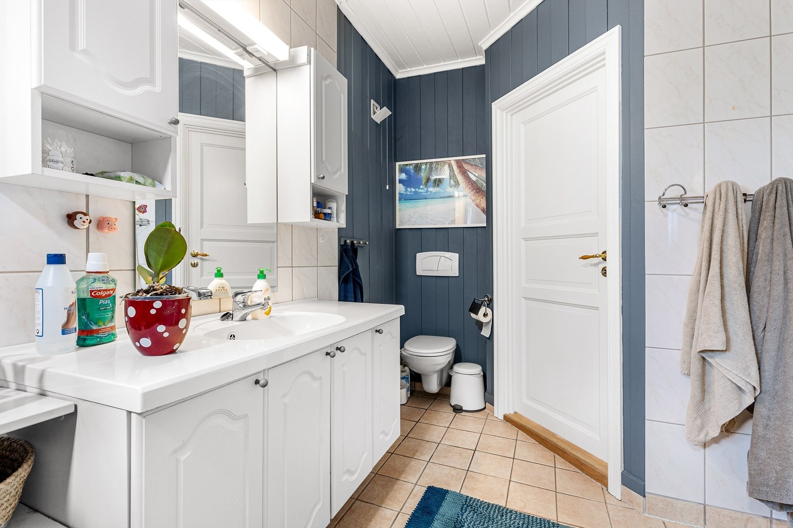 Leilighet 2: Delvis flislagt baderom fra 2004 innredet med helstøp servant på underskap, overskap, speil, dusjkabinett, vegghengt wc og plass for vaskemaskin og tørketrommel Galleribilde