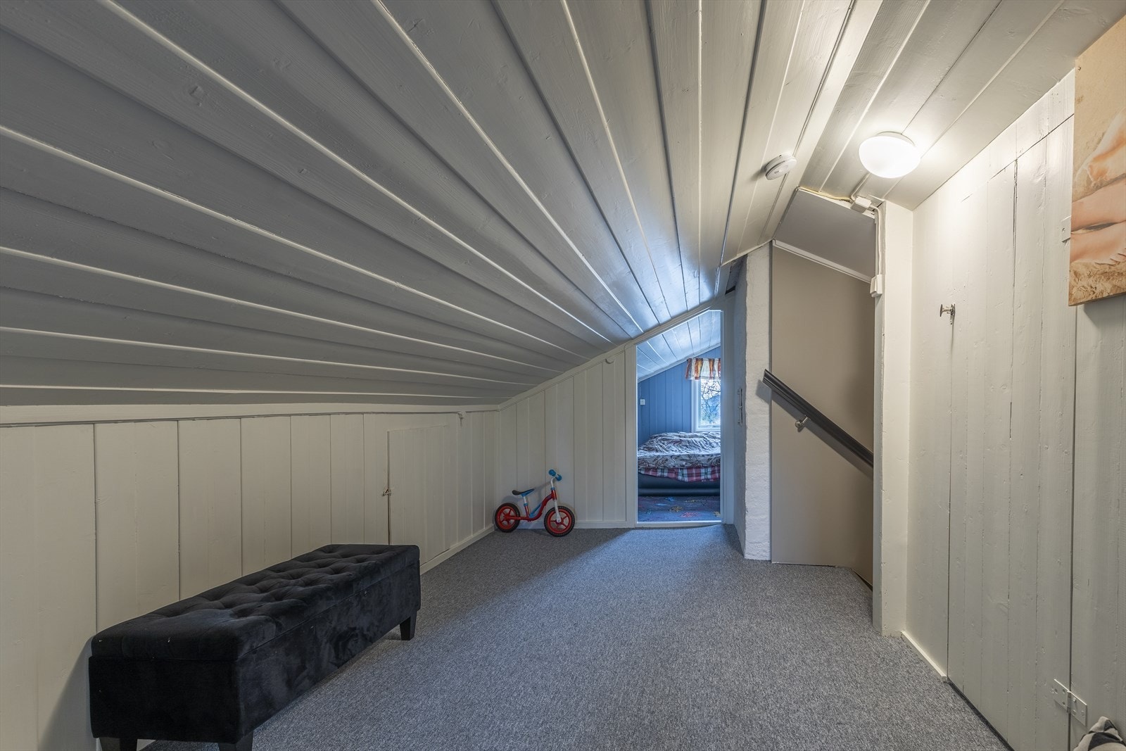 Hall med trapp mellom to innredet rom. Loftet er ikke godkjent for varig opphold og er heller ikke målbar pga takhøyden. Galleribilde