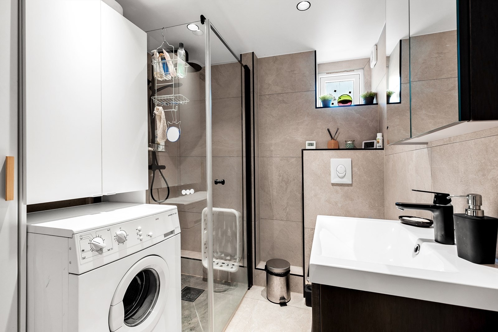 Hybel/Leilighet 4: Lekkert og flislagt baderom fra 2021. Helstøpt servant på underskap, overhengende speilskap og dusjnisje. Plass for vaskemaskin og tørketrommel Galleribilde