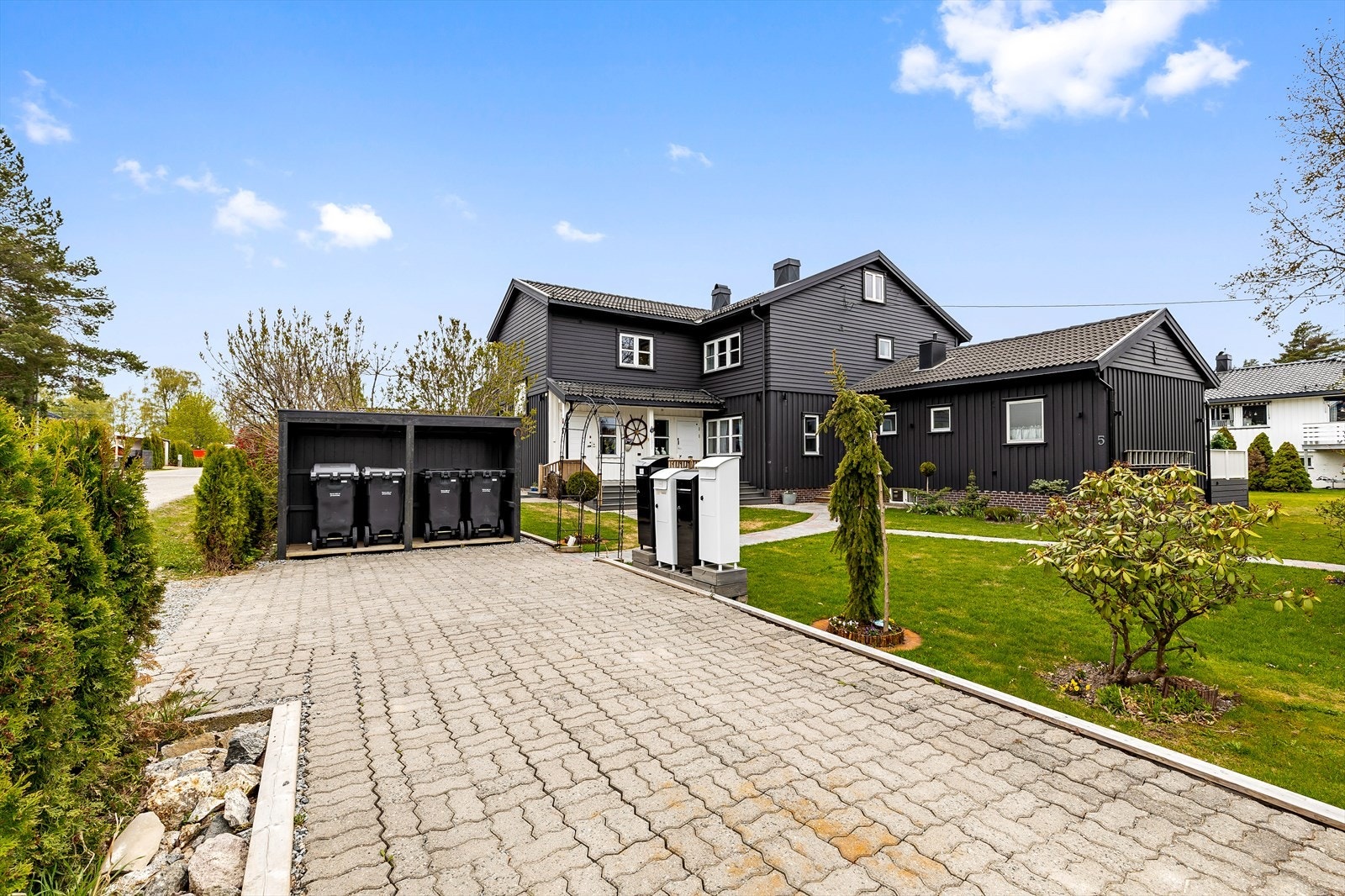 En parkeringsplass ved søppelboksene og postkassene Galleribilde