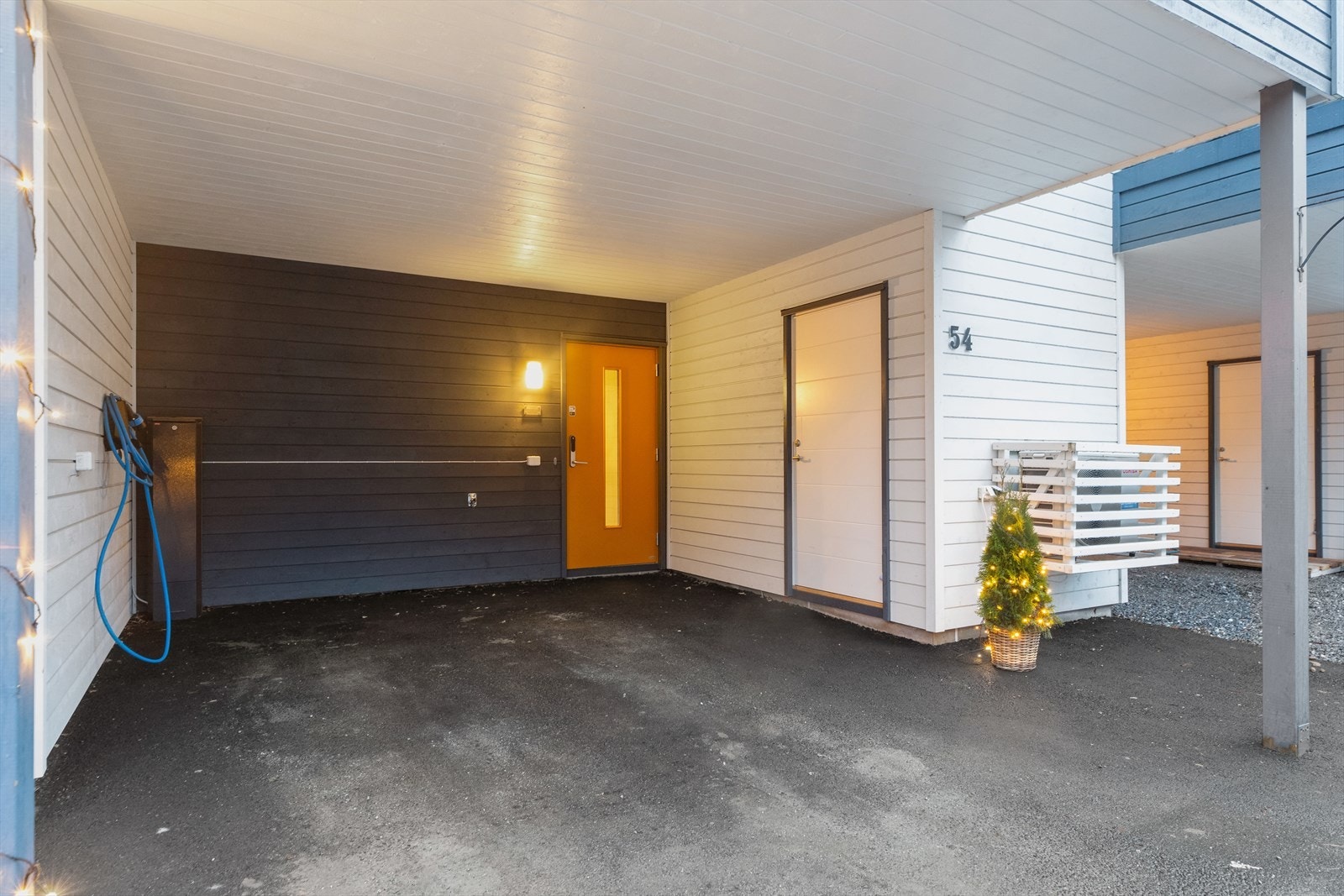 Under balkongen har boligen inngangsparti, sportsbod og carport med elbillader. Galleribilde