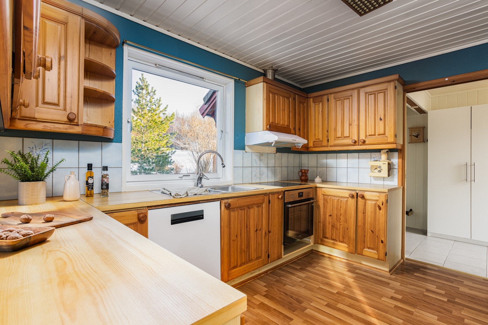 Furu i profilert utførelse med flislagt baclsplash i hvitt. Galleribilde