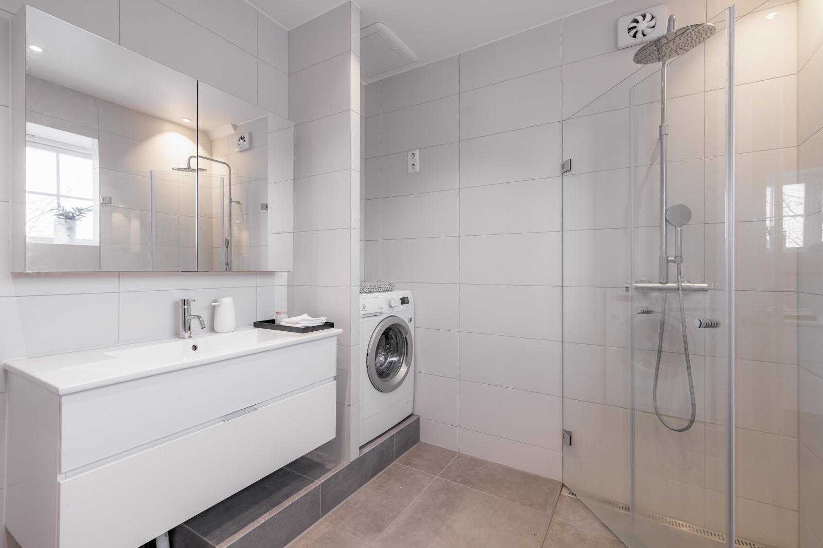 Badet er utstyrt med vegghengt wc, servant med skuffer under og speilskap over, dusj i hjørne samt badekar. Opplegg for vaskemaskin. Galleribilde
