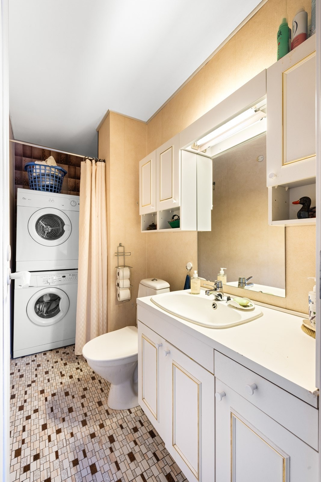 Badet er innredet med klosett, servant nedfelt i innredning, dusjhjørne og opplegg for vaskemaskin. Galleribilde