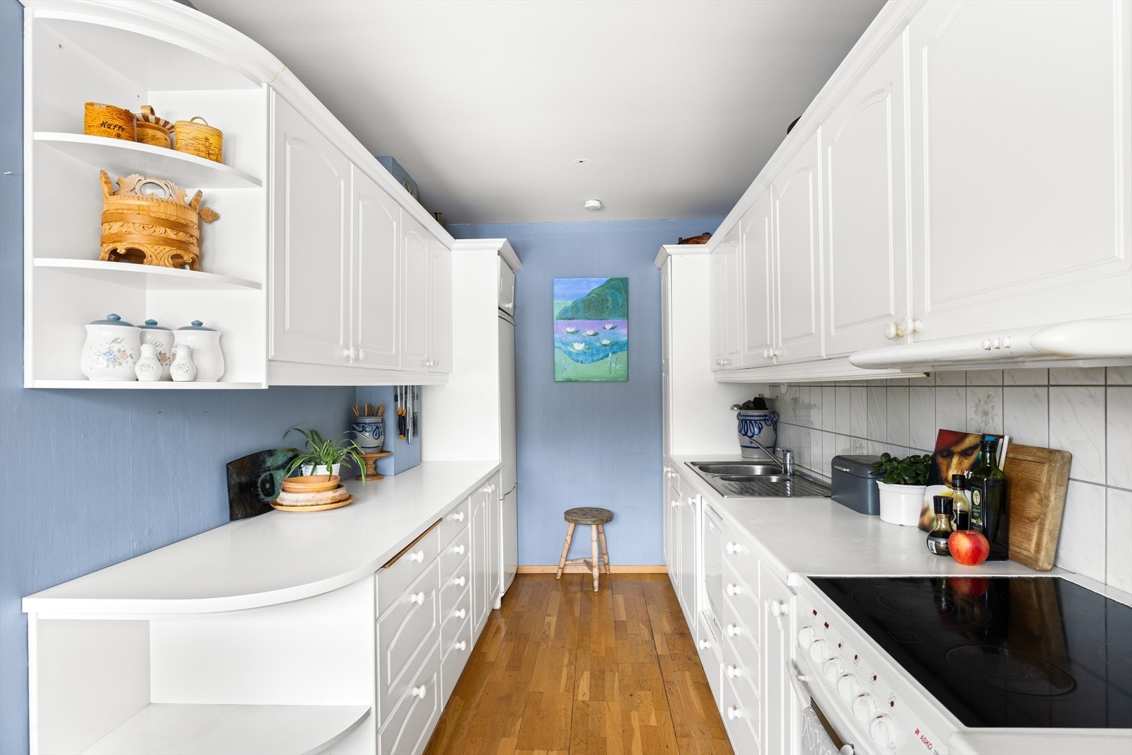 Kjøkkenet har profilerte fronter, laminat benkeplate med nedfelt vask- og skyllekum samt fliser og belysning over benkeplate. Galleribilde