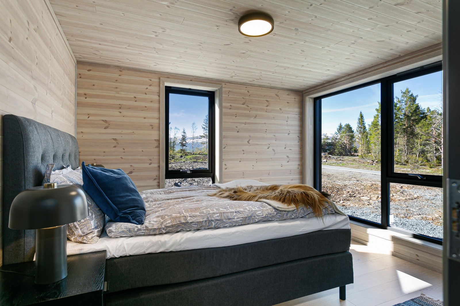 Store vinduer som slipper inn mye lys på soverommet. Illustrasjonsfoto. Galleribilde