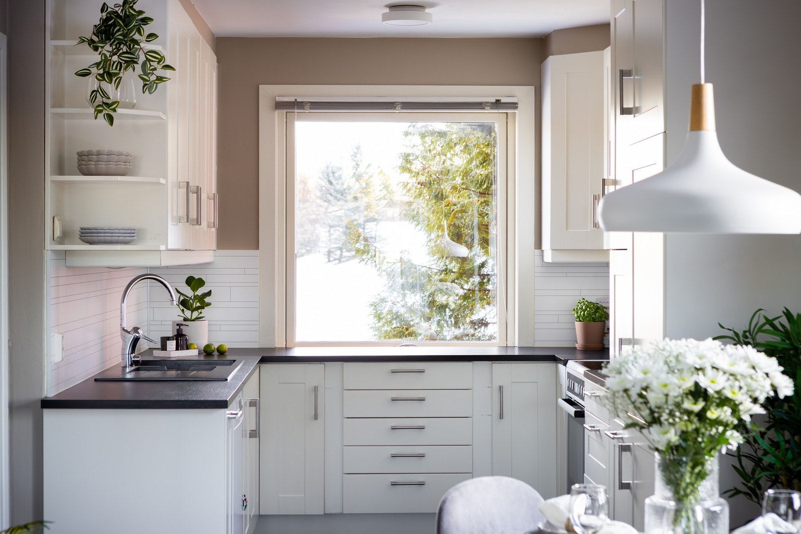 Lys, profilert kjøkkeninnredning med laminat benkeplate og oppvaskkum med ett-greps armatur. Galleribilde