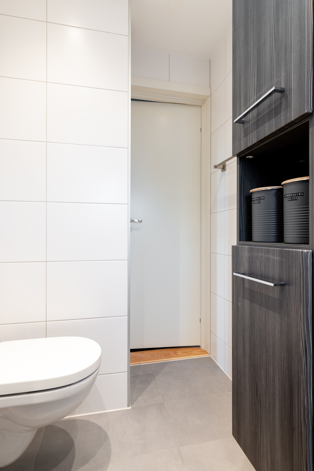 Videre er det vegghengt toalett og dusjhjørne med svingbare dører som frigjør plass på gulvet. Opplegg for vaskemaskin. Galleribilde