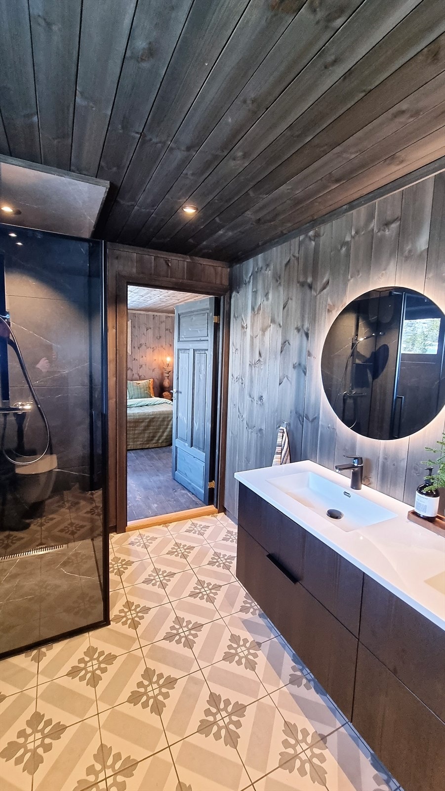 Badet har dusjnisje med store fliser på vegg og i taket, samt downlight. Galleribilde