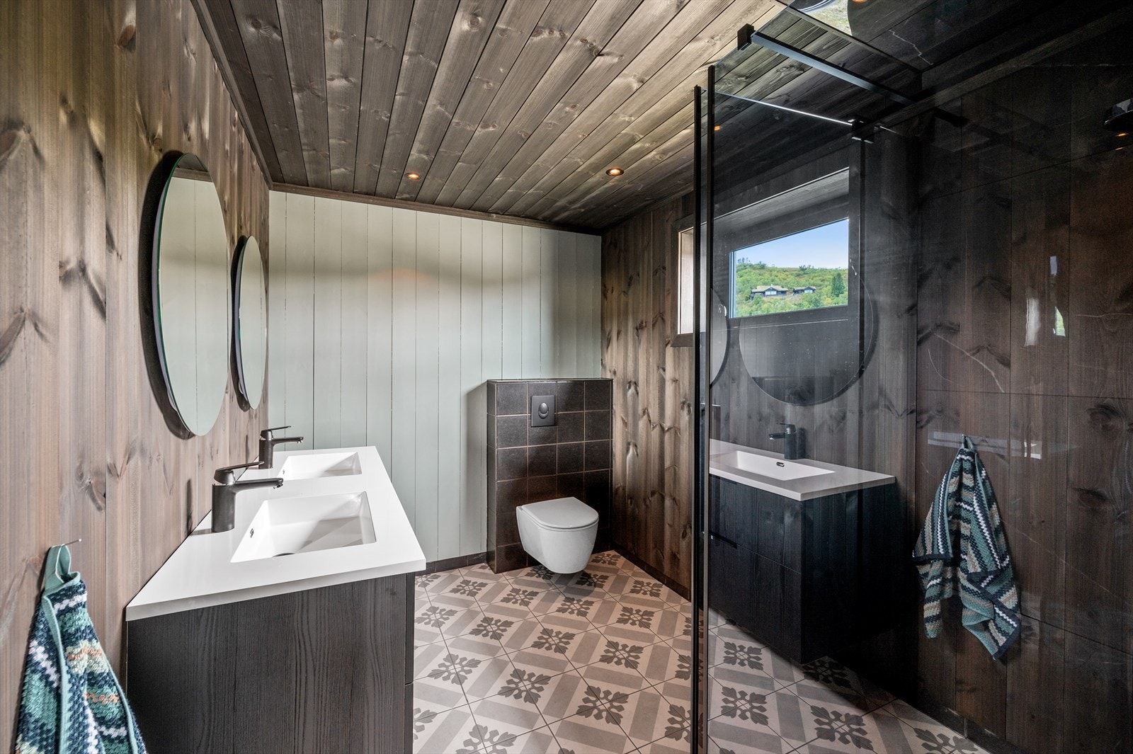 Hovedbadet med flotte fliser på gulv og fondvegg. Galleribilde