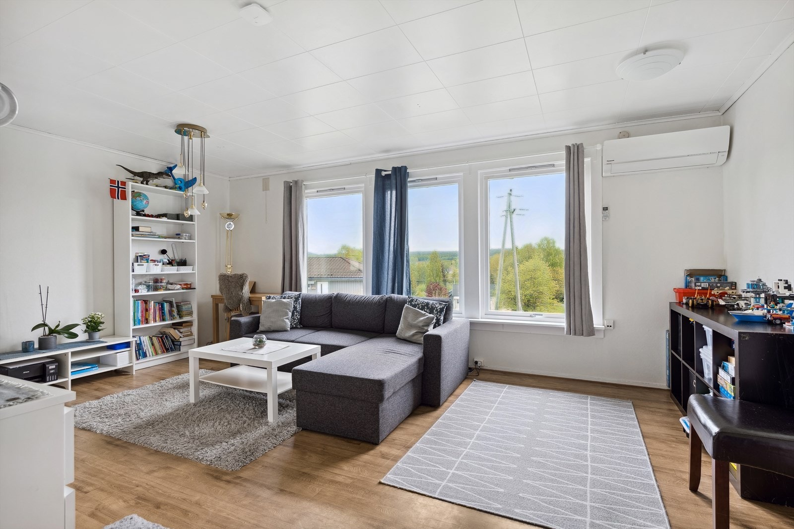 Stue i utleiedel med store vindusflater, lysmalte vegger og varmepumpe. Galleribilde