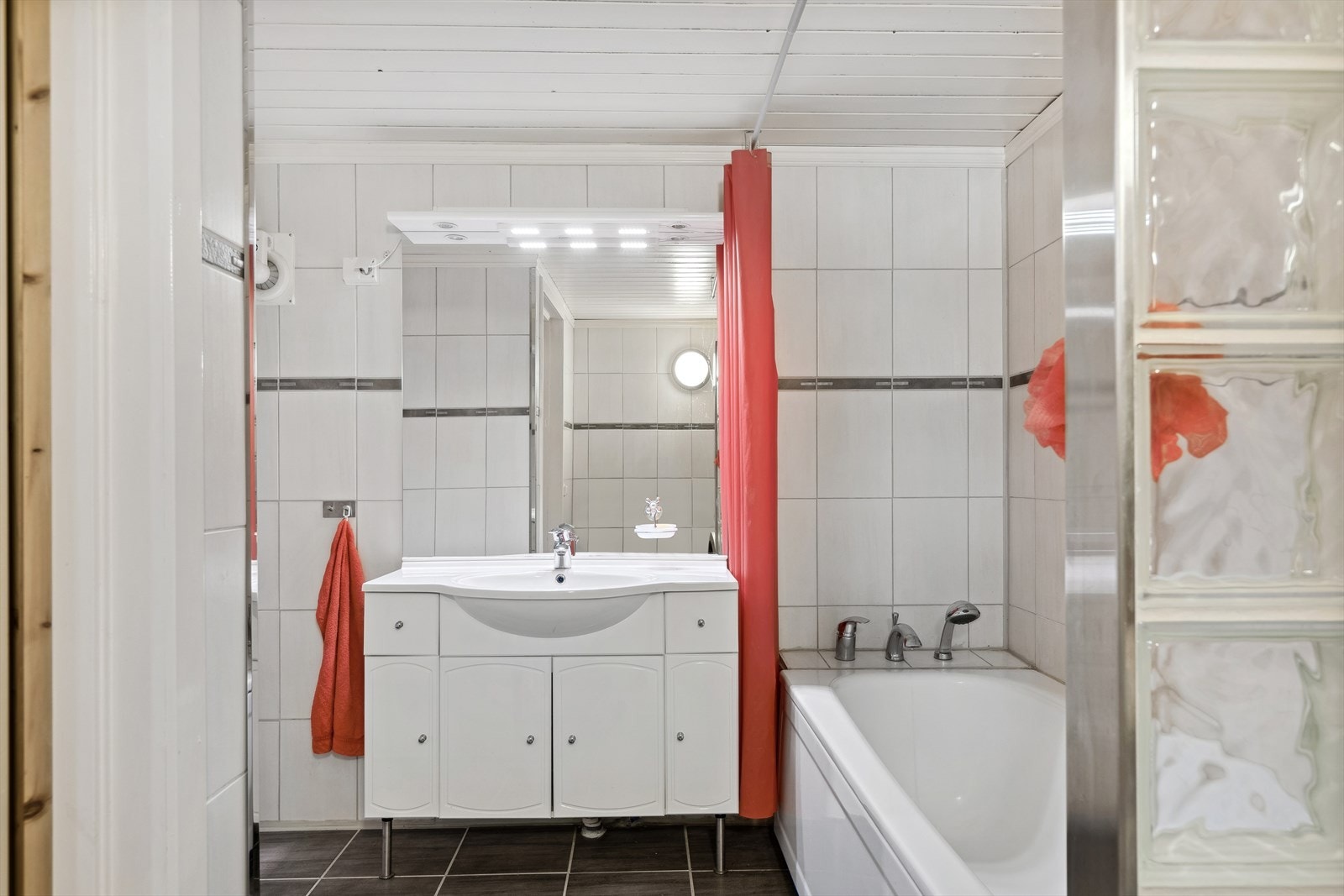 Badet i kjelleretasjen har flislagte flater og er innredet med badekar, servantinnredning og toalett. Galleribilde