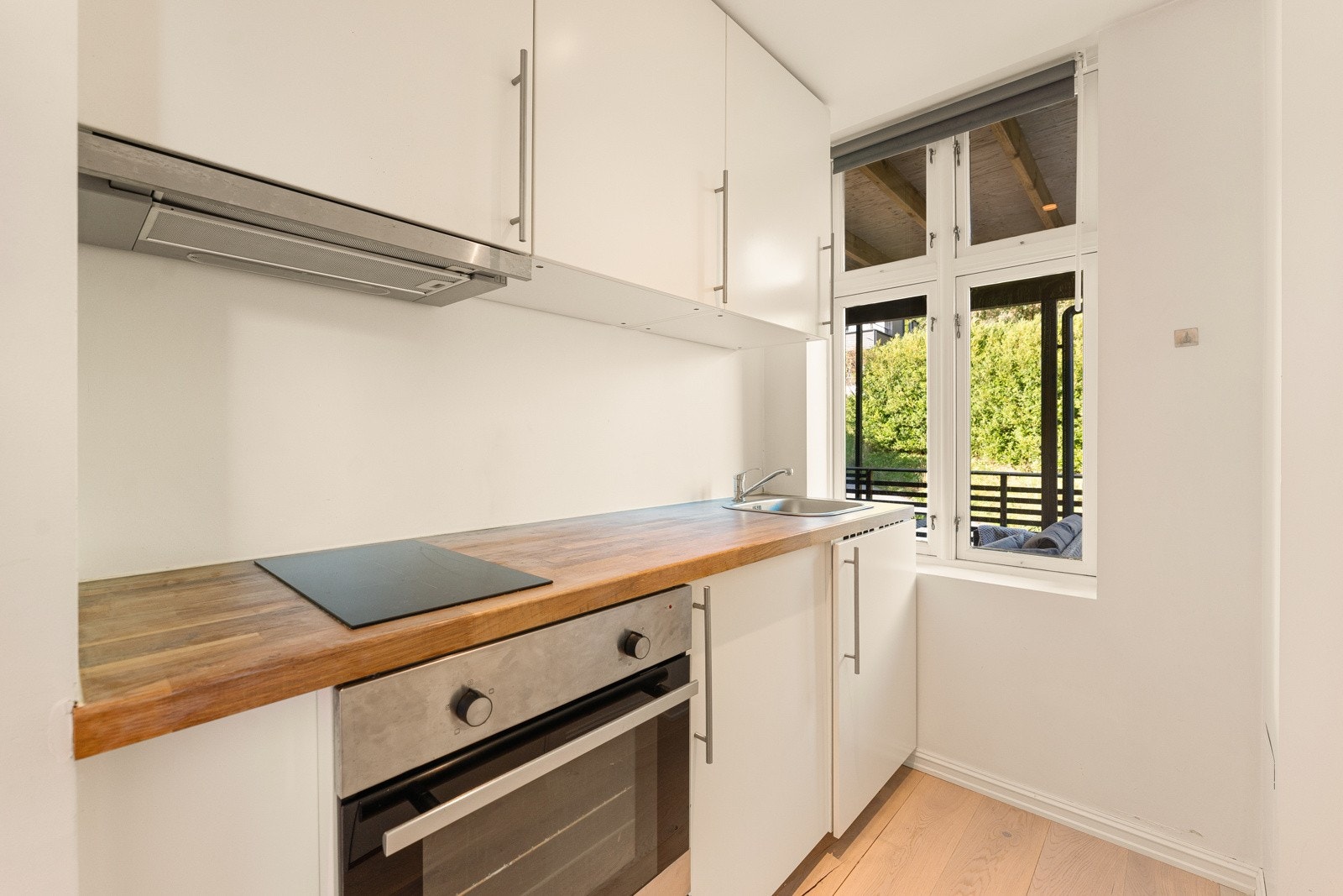 Kjøkkenet har glatte fronter og benkeplate i heltre med nedfelt stålvask. Galleribilde