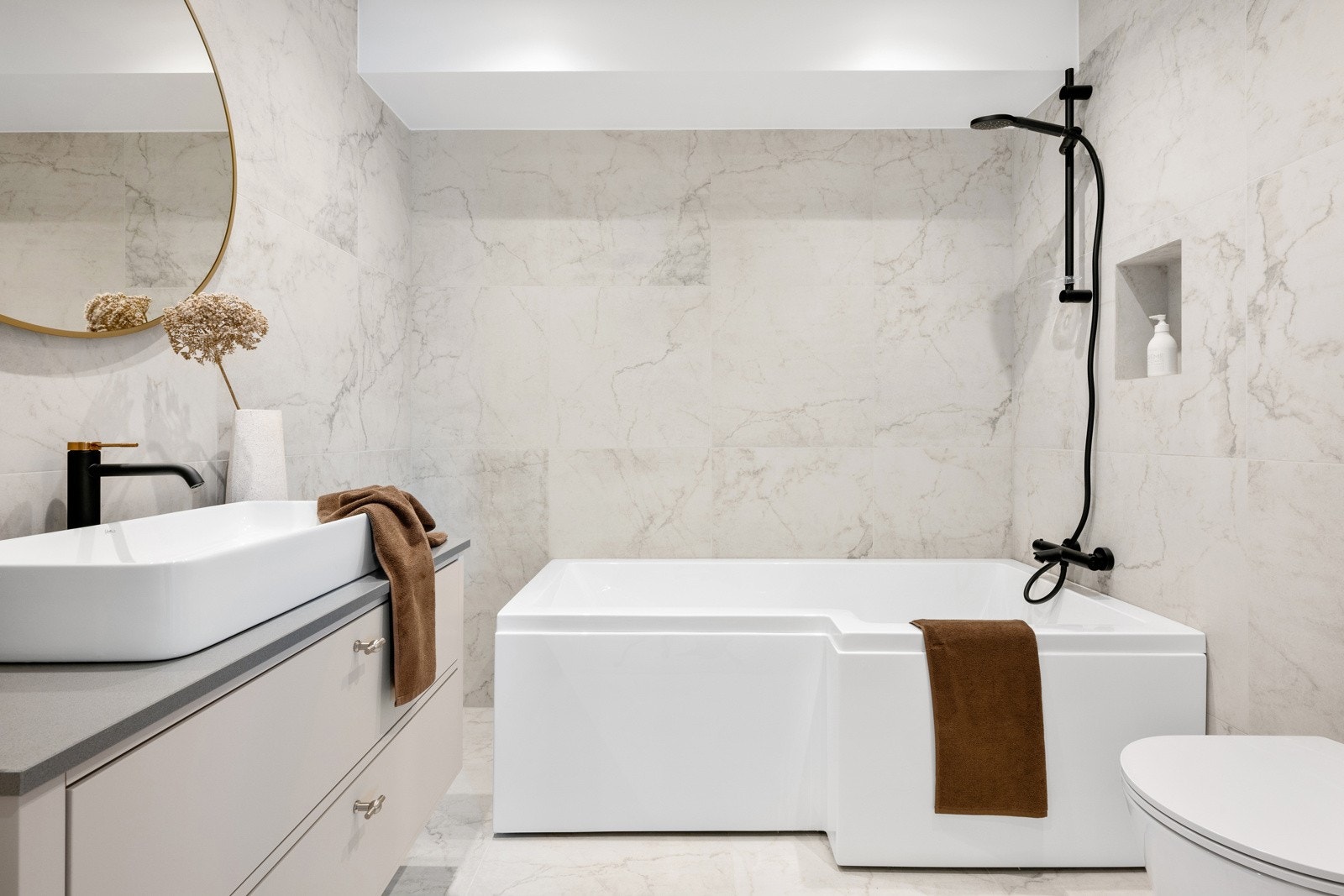 Familiebadet i 2. etasje har et fint dusjbadekar med god dusjplass, moderne og sort dusjarmatur, og fin hyllenisje i vegg. Galleribilde