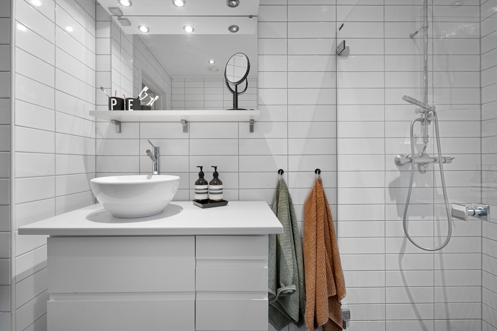 Badet er helfliset med vegghengt toalett, dusjvegger og moderne innredning med servant. Galleribilde