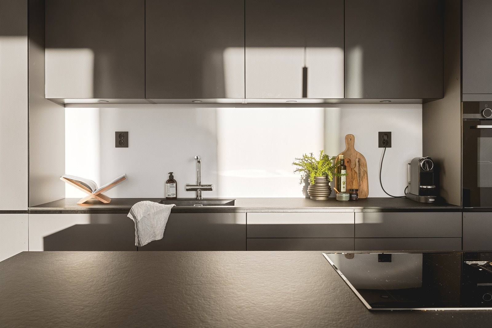 Stilren kjøkkeninnredning med glatte fronter, praktisk arbeidsflate og godt med oppbevaringsplass. Galleribilde