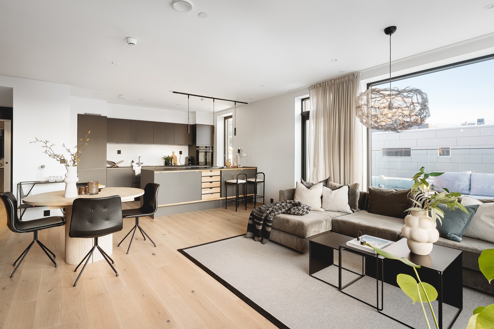 Stuen og kjøkken i åpen løsning, samtidig som rommet fortsatt har naturlige soner til både sofagruppen og spisebordet. Galleribilde