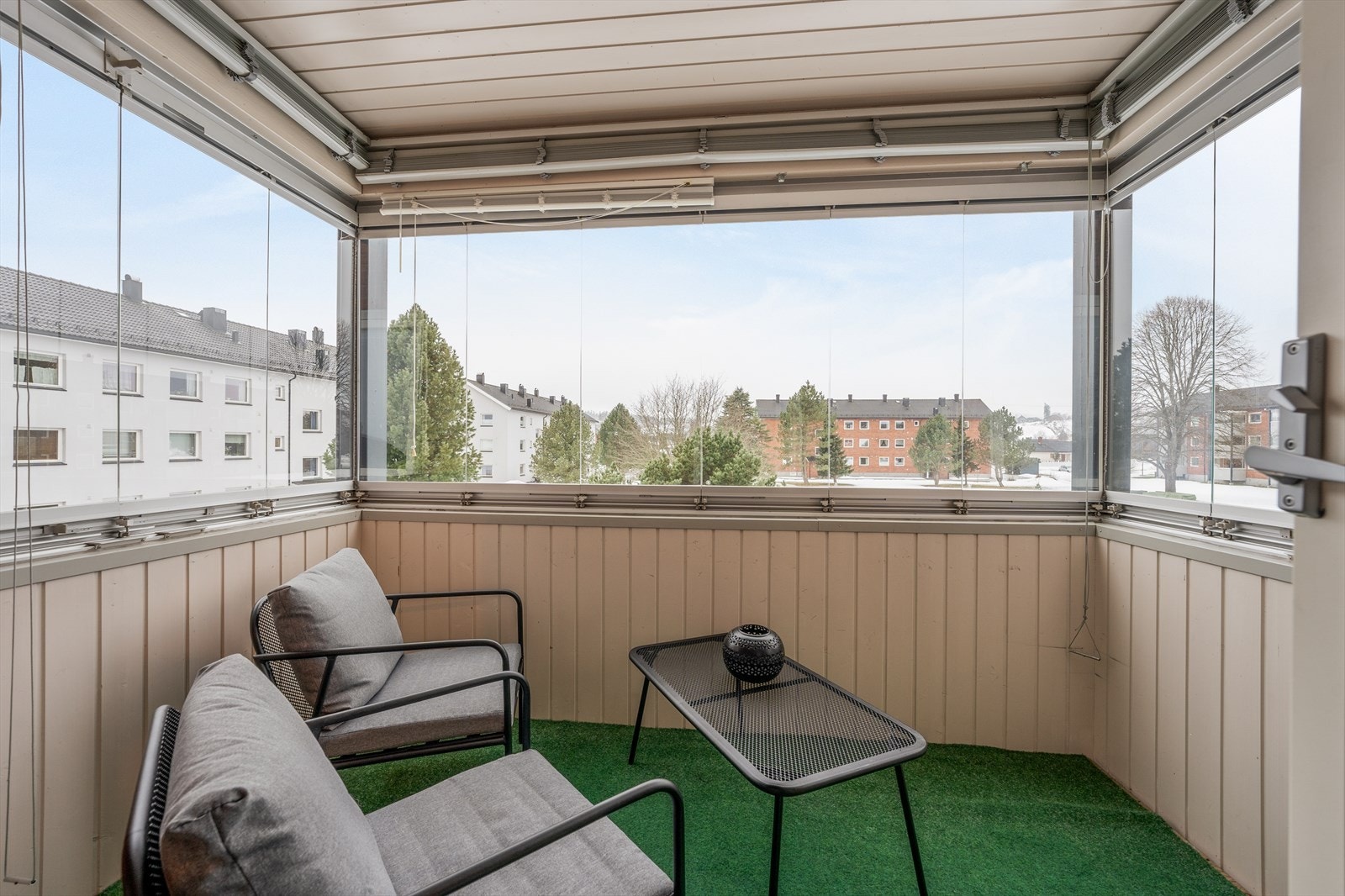 Balkongen ligger fint til med utsyn over fellesarealene, og vinduene her kan åpnes etter eget ønske. Balkongen kan benyttes som et ekstra rom store deler av året, med innvendige persienner for solskjerming og dobbelt el-stikk. Galleribilde