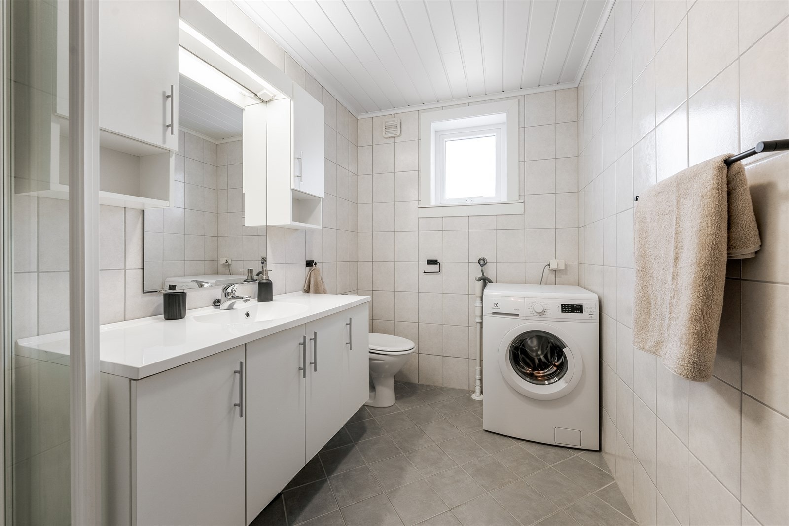 Leiligheten har et helfliset bad på 5 m2 med varmekabler i gulv. Her er det godt med oppbevaringsplass i innredning med heldekkende servant, samt i overskap. Galleribilde