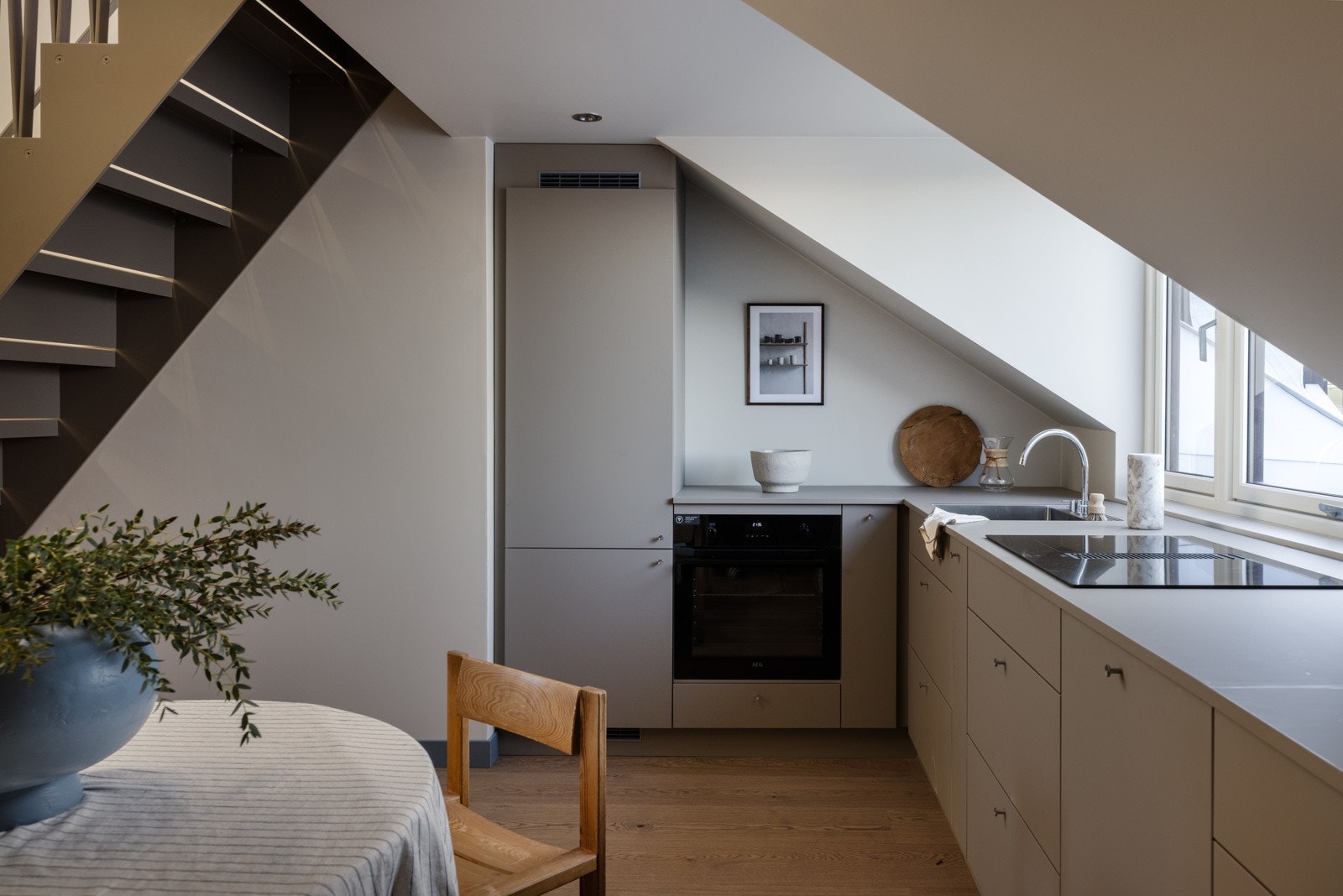 Integrerte hvitevarer som induksjon topp med integrert ventilator med avtrekk ut, stekeovn, oppvaskmaskin og kjøl/fryseskap. Galleribilde