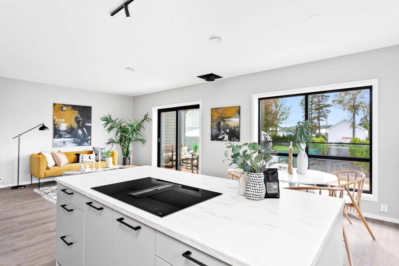 Den åpne stue-/kjøkkendelen er romslig, og det strømmer rikelig med naturlig lys inn fra de mange glassflatene. Galleribilde