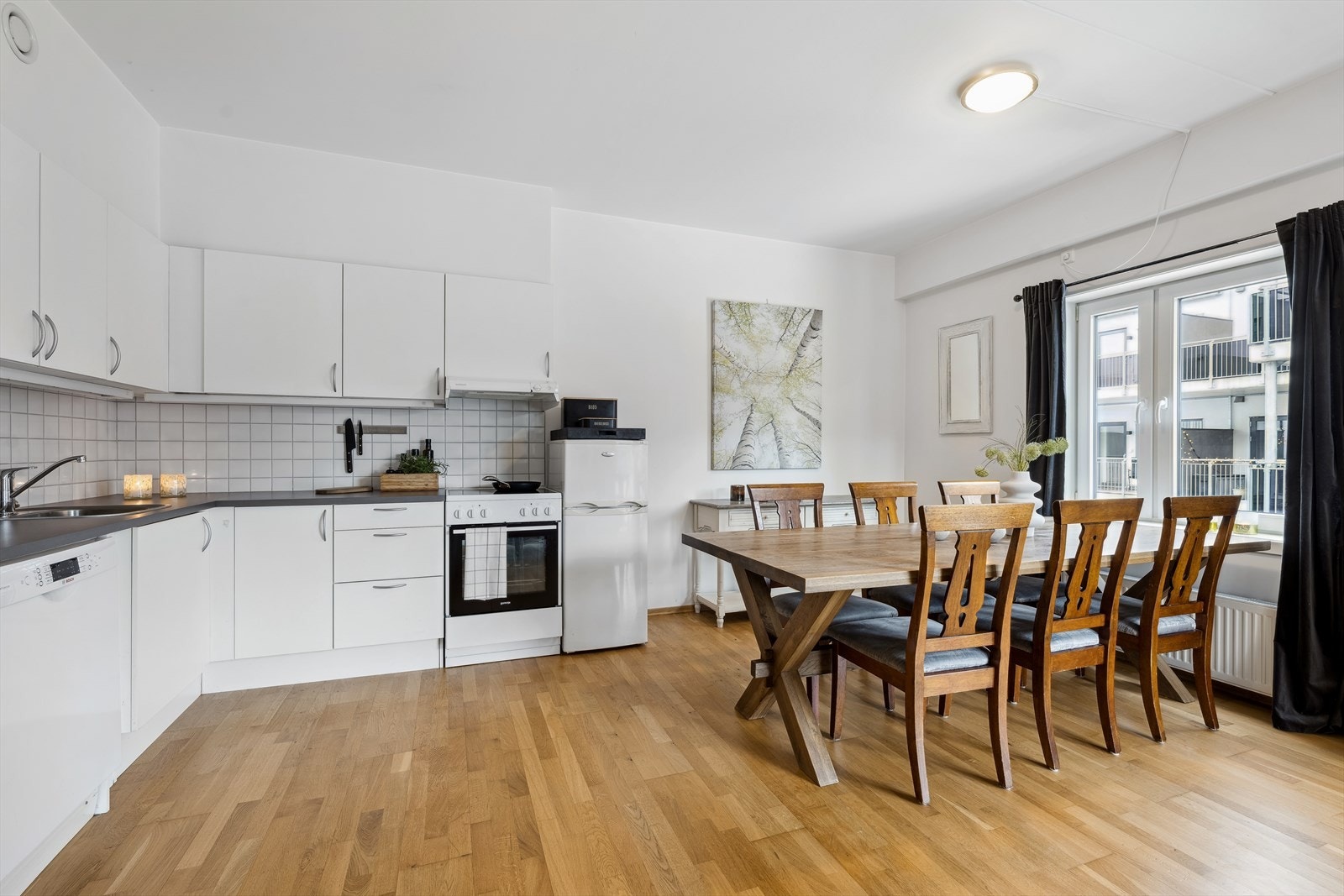 Det er godt med plass til stort spisebord mellom kjøkken og stue. Kjøkkeninnredningen kan også utvides med flere skap på langveggen ved behov. Galleribilde