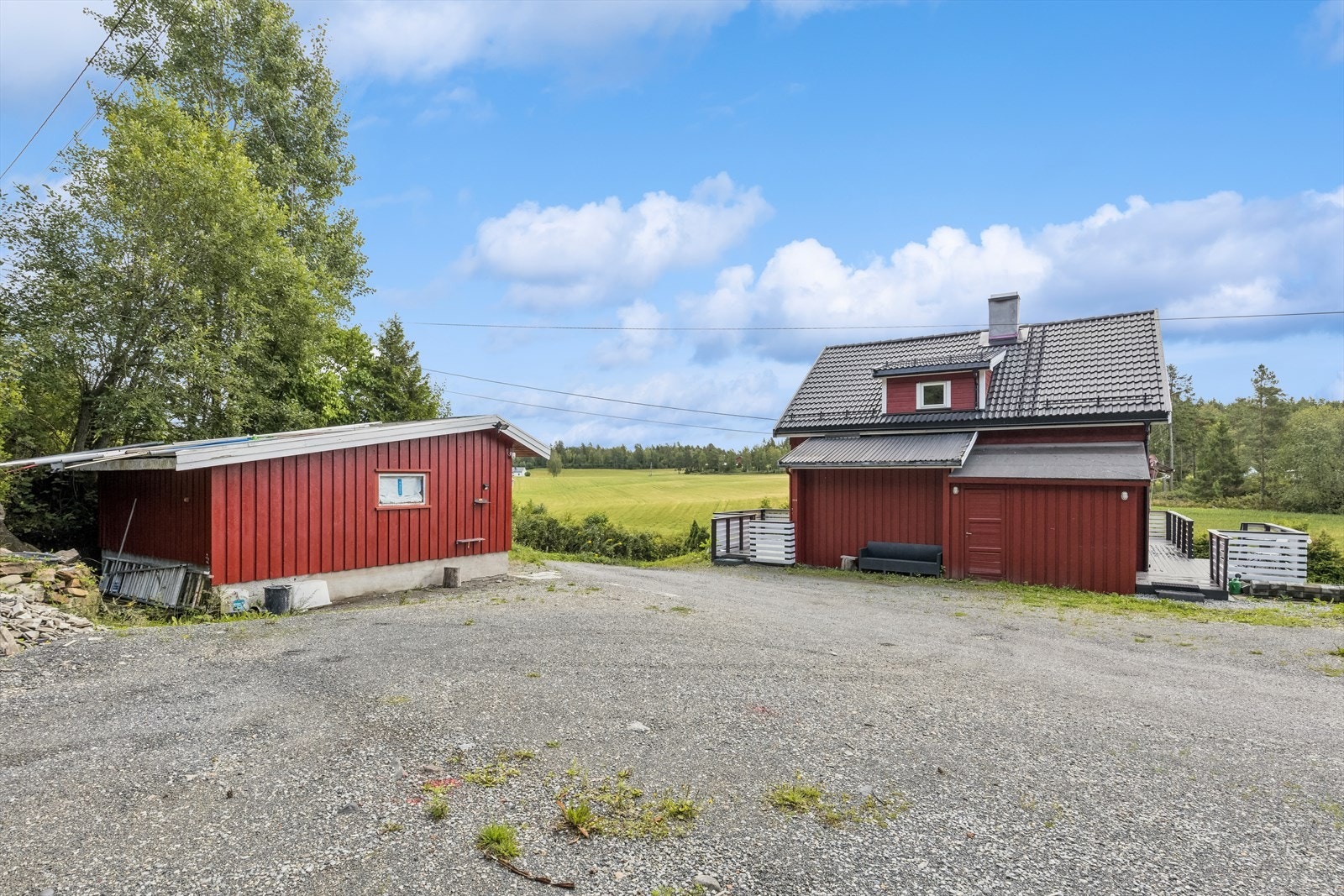Eiendommen har gruset gårdsplass med frittstående garasje. Galleribilde