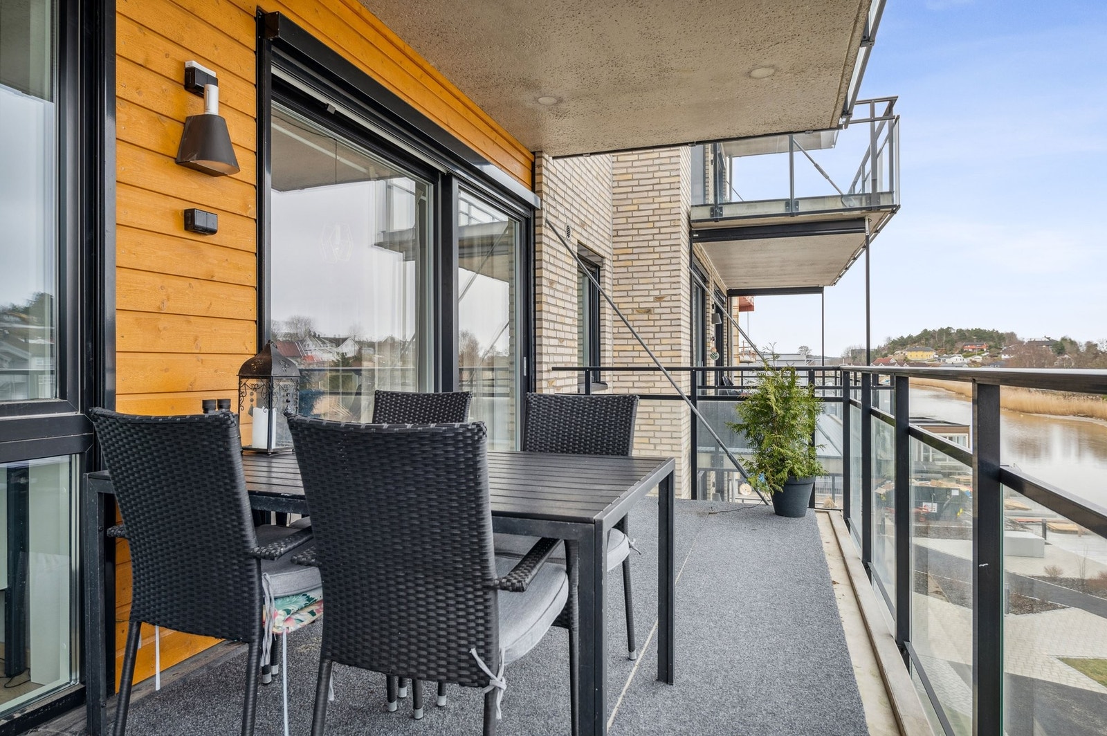 Utsikt fra vestvendt solrik terrasse på 13.5 m2. God plass for møbler, planter, solseng og grill. Praktisk med stikkontakt over bordet og stor skyvedør til "utestuen" hvor du nyter sommeren. Galleribilde