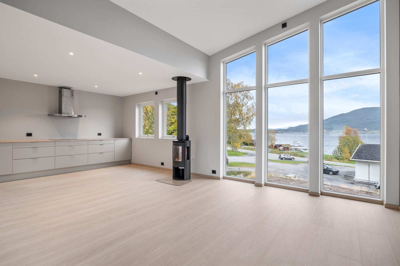 De store vindusflatene gir masse naturlig lys inn i boligen. I himlingen ved kjøkken er det også downlights. Galleribilde