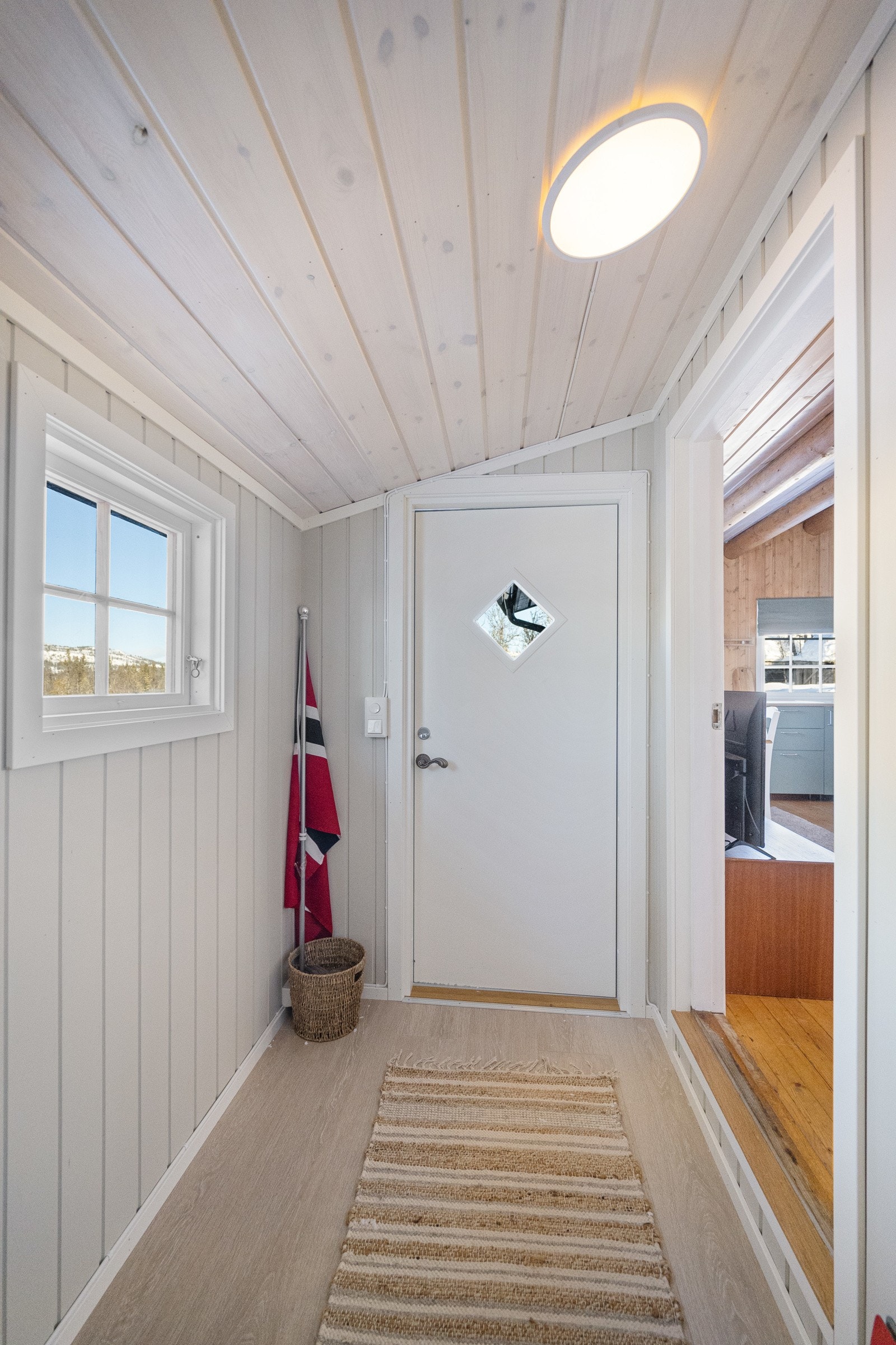 Lys og hyggelig entrè med plass til å henge fra seg klær og sette fra seg sko Galleribilde