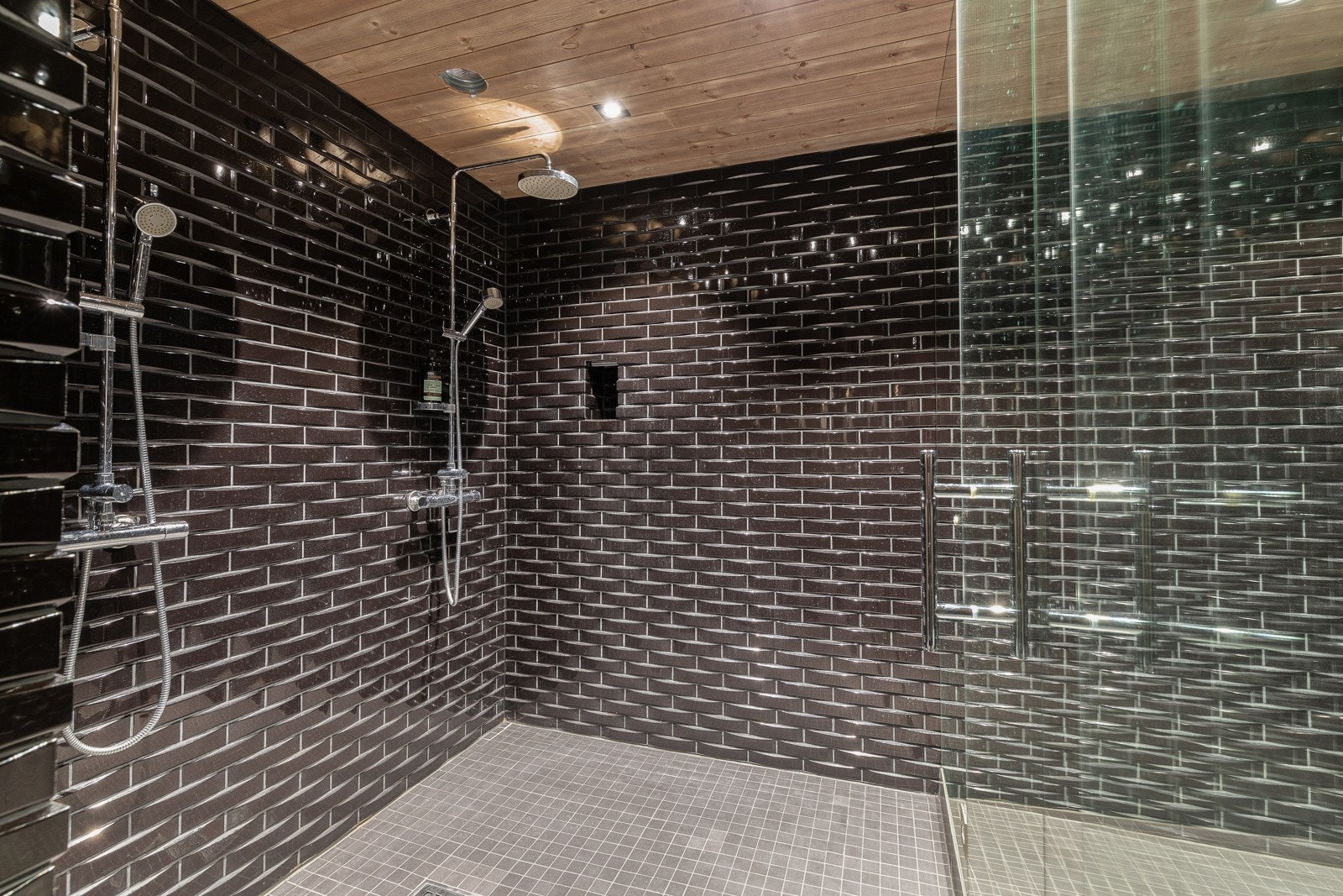 Dusjrom med to regnfallsdusjar. Himling har panel med spotbelysning. Galleribilde