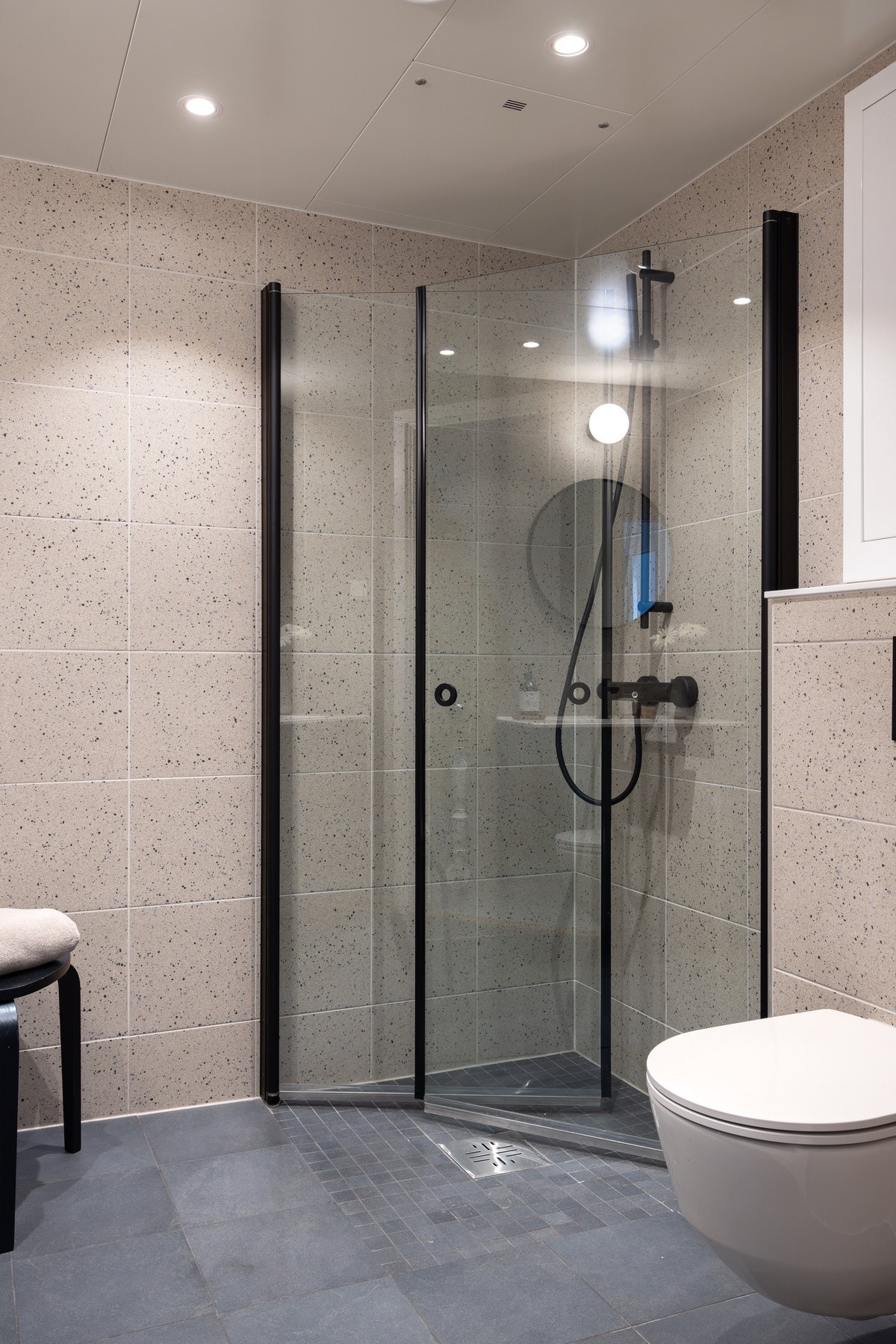 En romslig dusj med sort innramming og sort armatur Galleribilde