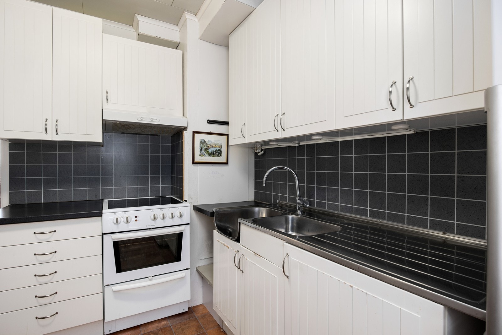 Lys kjøkkeninnredning med frittstående hvitevarer Galleribilde