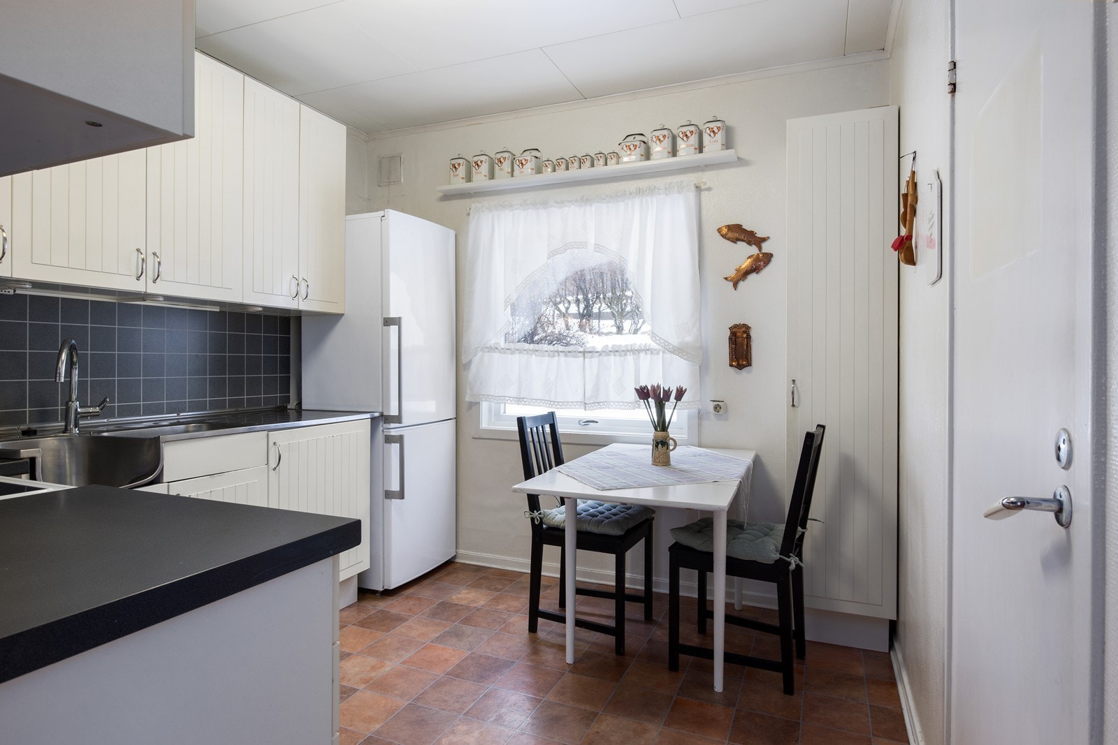 Koselig kjøkken med spisesplass foran vindu Galleribilde