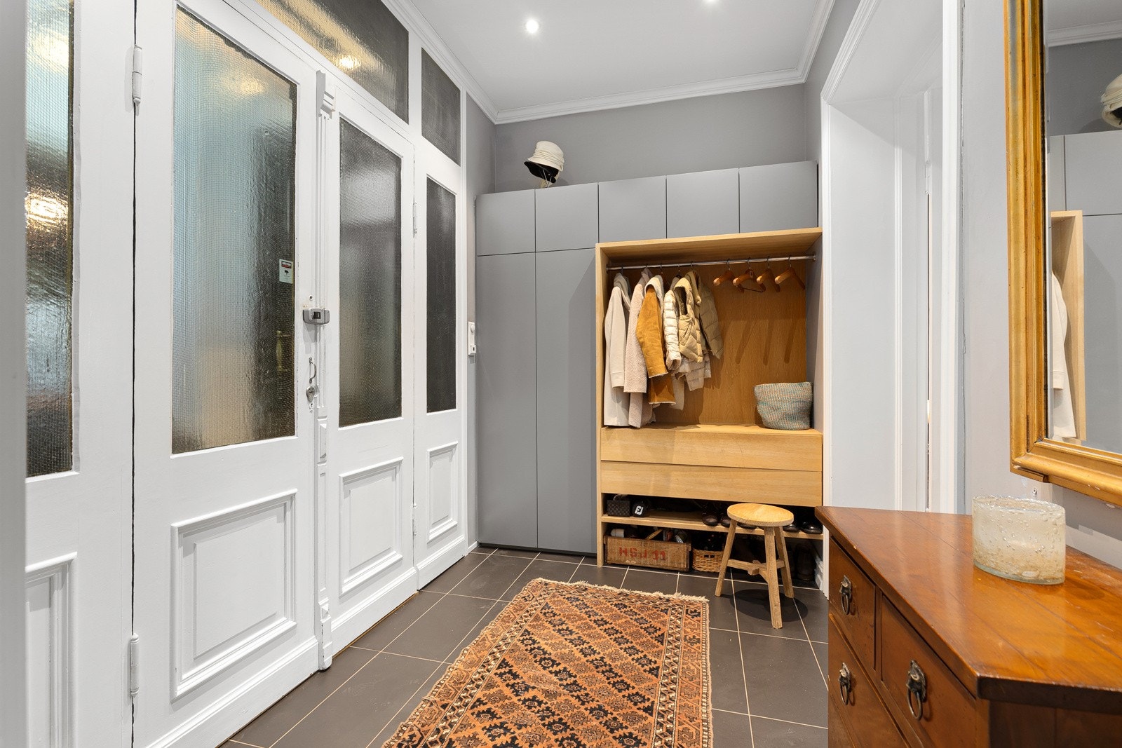 Meget innbydende og representativ entré med garderobe, downlights i himling og fliser på gulv Galleribilde