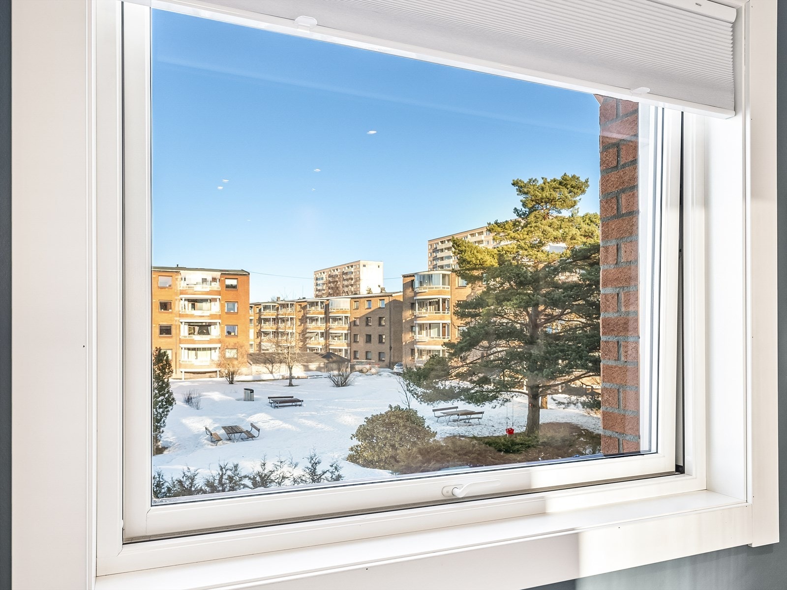 Vindu med utsikt til velpreparerte fellesareal og vinterlandskap. Galleribilde