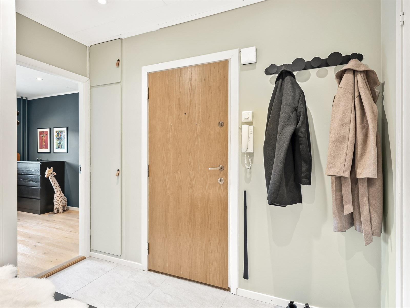 Velkommen inn i en praktisk entré med lyse vegger. Galleribilde