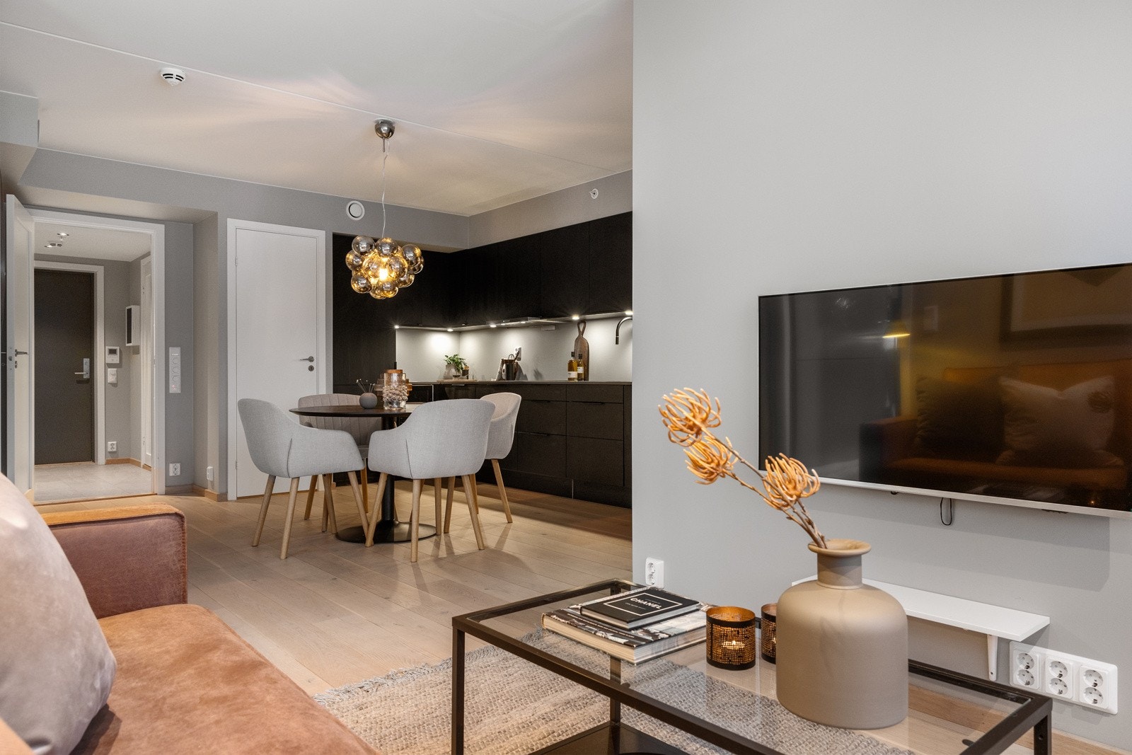 En lys og sosial sone med åpen stue- og kjøkkenløsning. Galleribilde