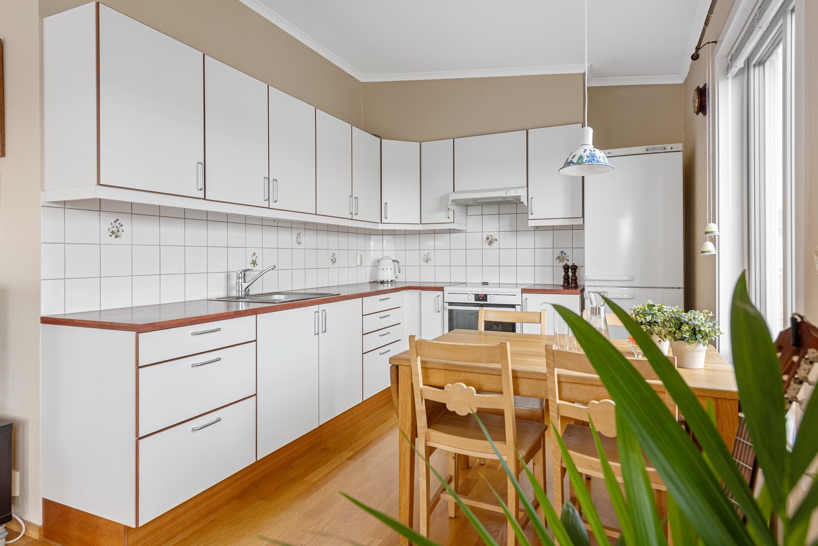 Kjøkkenet har lyse slette fronter og laminat benkeplate. Det er godt med skap- og benkeplass Galleribilde