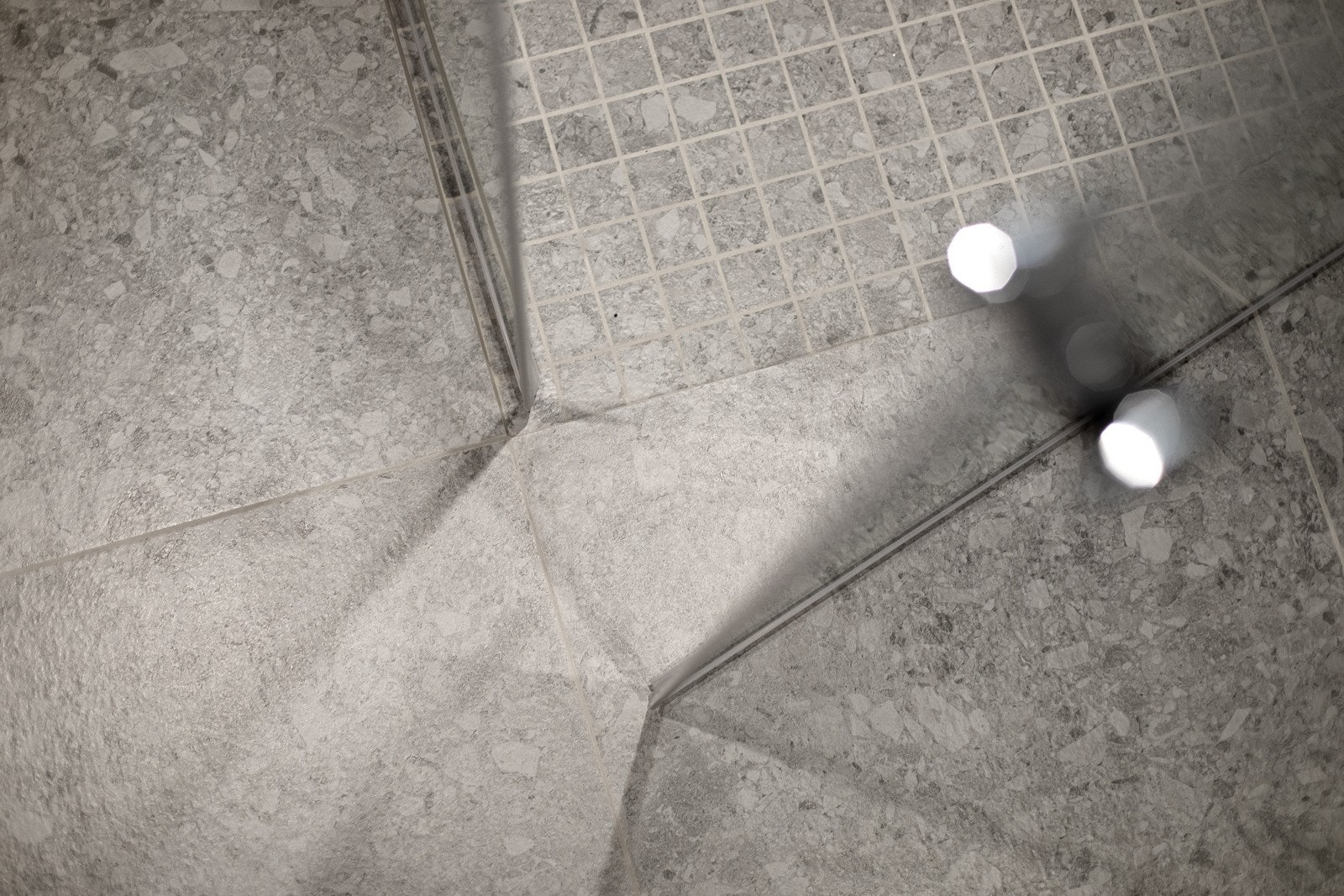 Nedsenket dusjsone med mosaikkfliser på gulv, innfellbare glassdører og både hånd- og regnfallsdusj. Galleribilde