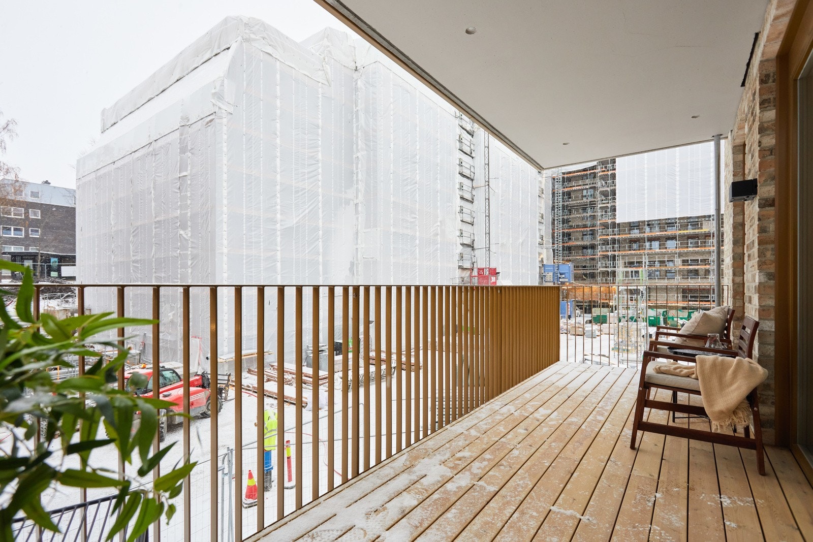 Balkongen er delvis overbygget, har impregnerte terrassebord på gulv, spilerekkverk og skillevegg mot nabo. Galleribilde